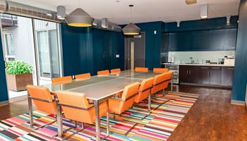 a conference room with a long table and orange chairs